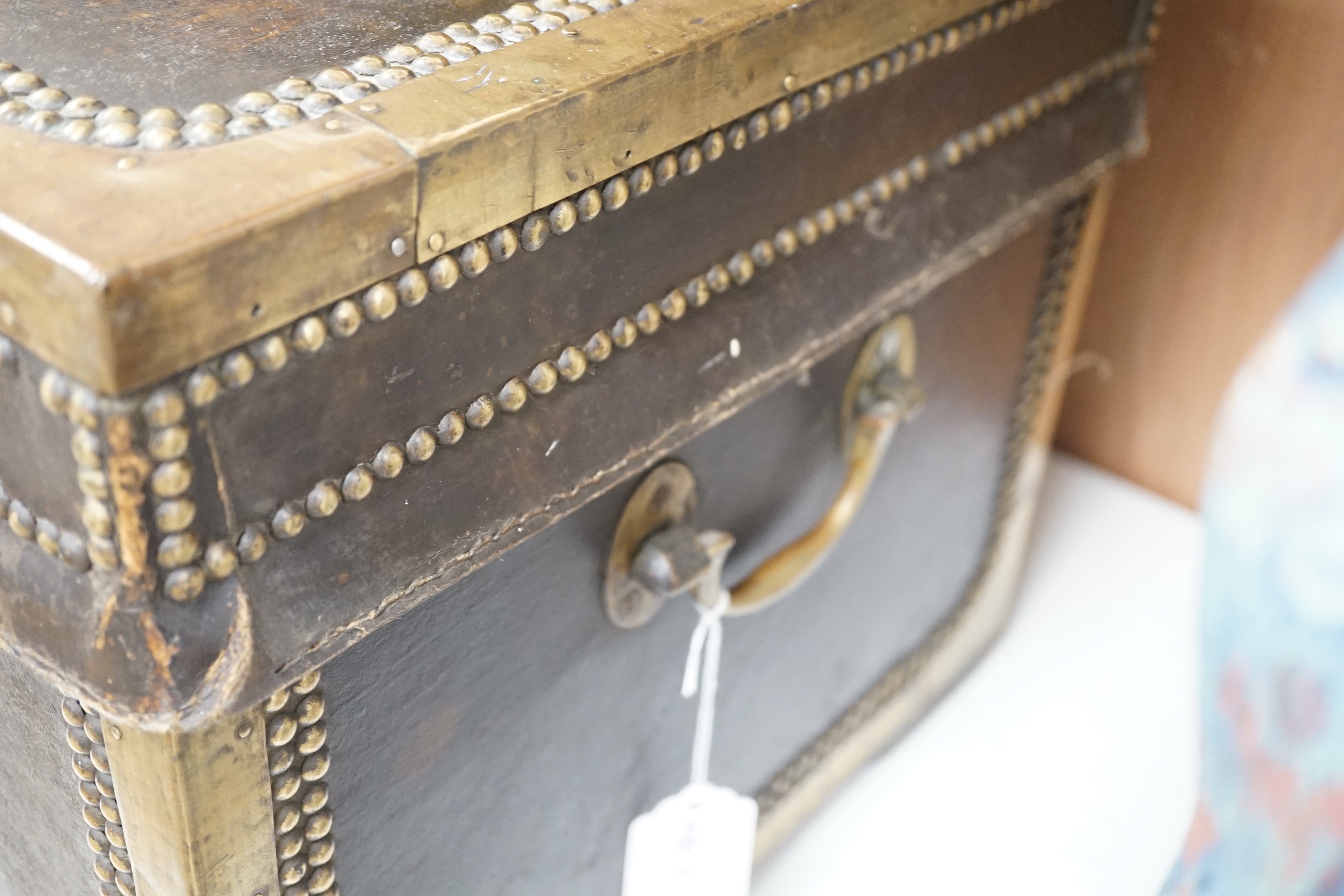 A 19th century leather and brass studded and mounted travelling trunk with metal and printed paper lining, 73.5 cm wide x 33cm high x 39cm deep